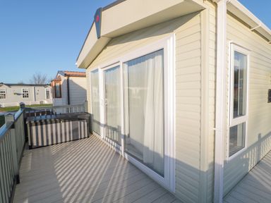 A balcony outside a mobile home with glass sliding doors and a storage box at Downtime Lodge near Felton