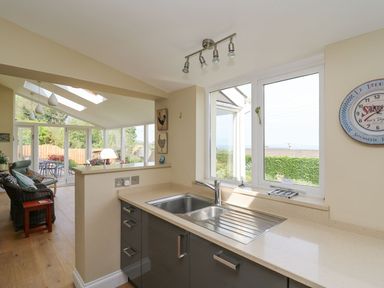 A kitchen sink with countertop and window overlooking garden at Tree Tops in Newport Pembrokeshire
