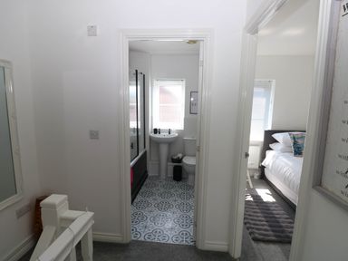 A hallway with doors leading to a bathroom and bedroom at Ty Bach Twt Llanelli