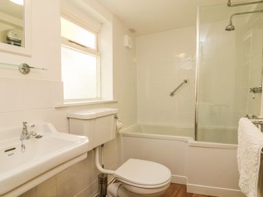 A bathroom with a sink toilet bathtub and a window at Little Dragons in Dunster near Minehead