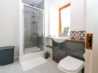 A bathroom with a shower cubicle a sink with cabinet and a toilet at 49 Castlegate in Jedburgh