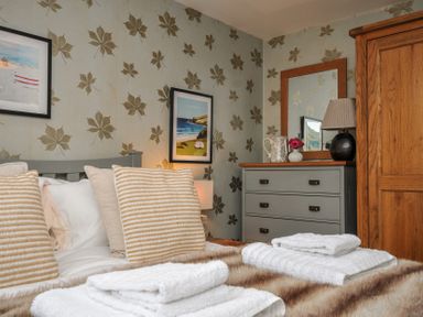 A bedroom with a bed and dressing table at The Hayloft in Lostwithiel