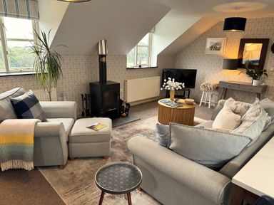 A living room with seating and a stove at The Hayloft in Lostwithiel