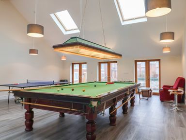A games room with a snooker table ping pong table chairs and skylights at Oak Cottage in Aylesbeare