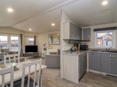 A kitchen and dining area with a living room visible beyond at Longdon Lodge in Wickhamford near Evesham