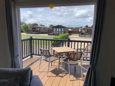 A balcony with a table and chairs at Longdon Lodge in Wickhamford near Evesham