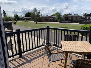 An outdoor seating area with table and chairs at Longdon Lodge in Wickhamford near Evesham