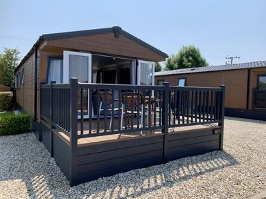 A holiday home with a deck and railing at Longdon Lodge in Wickhamford near Evesham