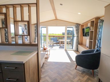 A living room with a sofa and television at Fir Lodge in Whitby