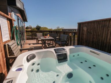 A hot tub on a wooden deck at Fir Lodge in Whitby