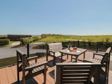 A patio with a table and chairs at Cherry Blossom Lodge in Whitby