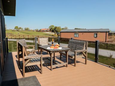 An outdoor seating area with wooden furniture at Cherry Blossom Lodge in Whitby