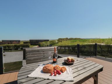 An outdoor table with food items and drinks at Cherry Blossom Lodge in Whitby