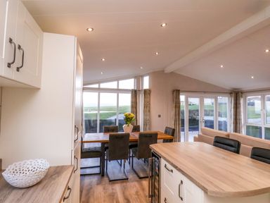 A kitchen and dining area with wooden countertops and a dining table with chairs at Holly Lodge in Whitby
