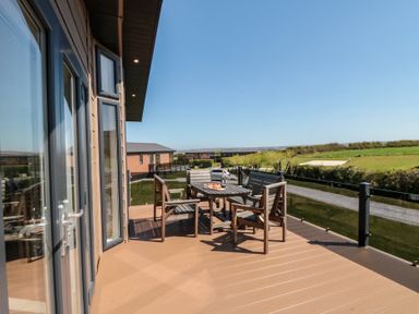 An outdoor seating area with a table and chairs at Holly Lodge in Whitby