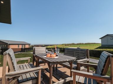 An outdoor seating area with a table and chairs at Holly Lodge in Whitby