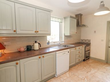 A kitchen with cabinets countertop sink dishwasher and stove at Dromclough Farmhouse in Dromclough near Listowel County Kerry