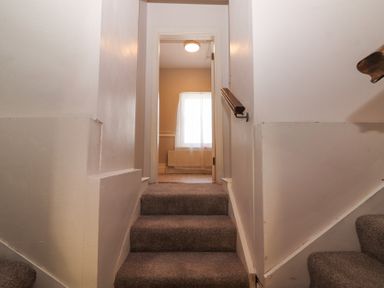 A carpeted stairway leading to a hallway with a window at Dromclough Farmhouse in Dromclough near Listowel County Kerry