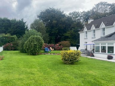 A garden with chairs and flowers at Dromclough Farmhouse in Dromclough near Listowel, County Kerry