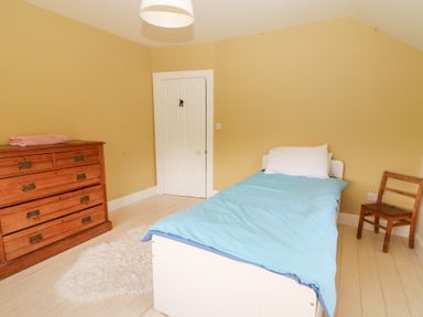 A bedroom with a bed, dresser, and chair at Shanti Gher Bantry