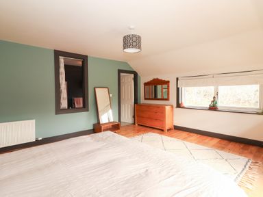 A bedroom with a bed, mirror, and chest of drawers at Shanti Gher in Bantry
