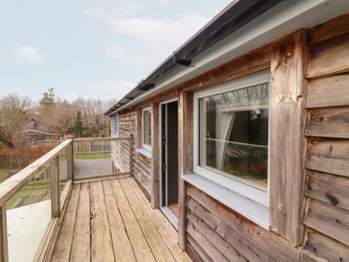 A wooden deck with windows and door at Shanti Gher in Bantry
