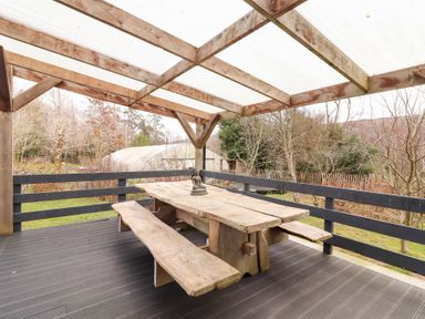 An outdoor area with a wooden table and benches at Shanti Gher in Bantry