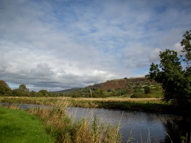 A river with grass and trees near hills at Ty Twt Teifi in Tregaron
