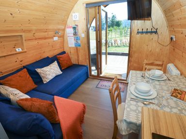 A living room with a sofa and dining set at Ty Twt Teifi, Llanddewi-Brefi