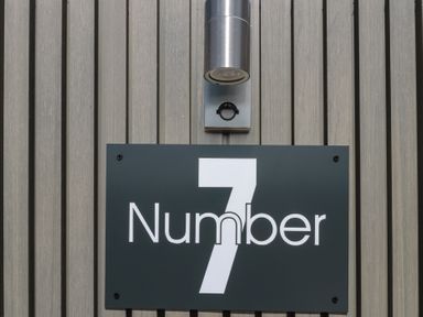 A house number sign with a light fixture at Number 7 in Bishop Sutton