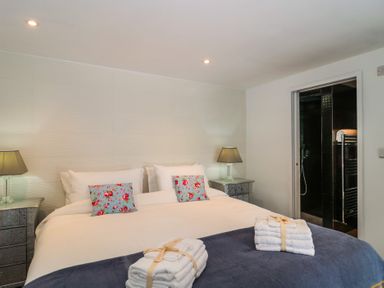 A bedroom with a bed and lamps at Number 7 in Bishop Sutton