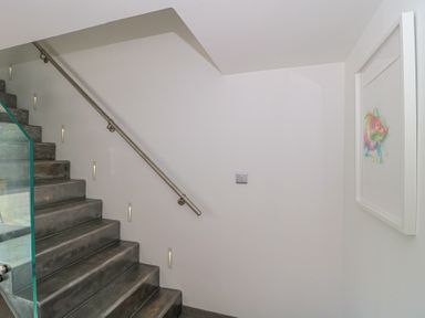 A staircase with a handrail and wall art at Number 7 in Bishop Sutton