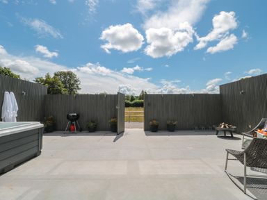 An outdoor area with a hot tub, grill, and seating at Number 7 Bishop Sutton