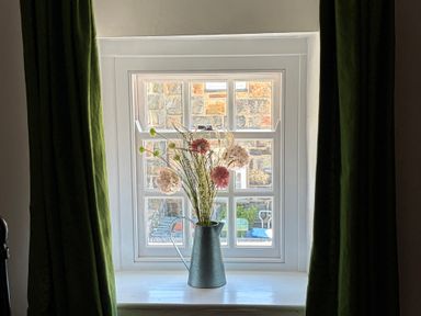 A window with flowers in a vase at Quarryman's cottage in Beddgelert