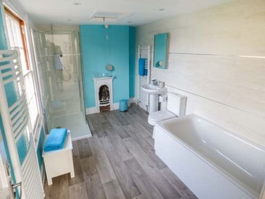 A bathroom with a bathtub toilet sink shower and towel racks at 1 Willow Cottage in Upton Upon Severn
