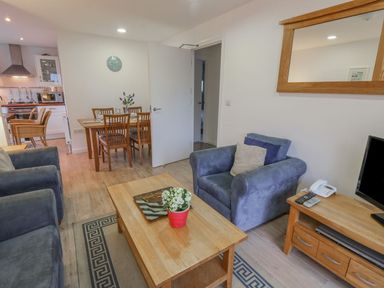 A living room with armchairs a coffee table and a dining table in the background at Pierpont D1 Norton near Yarmouth