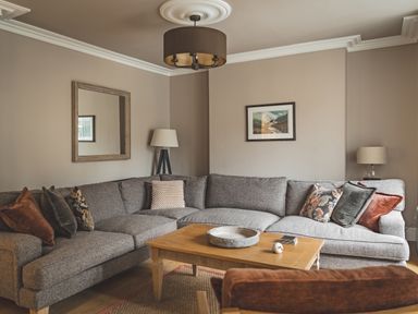 A living room with a grey sofa and coffee table at Tan Llan in Llanelltyd near Dolgellau
