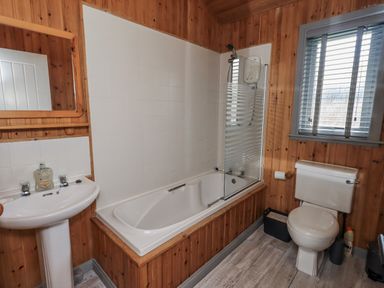 A bathroom featuring a bathtub, sink, toilet, and shower at Fig Tree Lodge in Hutton Roof near Penrith