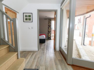 A hallway with stairs and a doorway leading to a bedroom at Coastguard Lookout in Wyke Regis