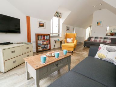 A living room with a television and sofa at Coastguard Lookout in Wyke Regis