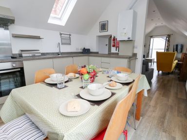 A kitchen with a table set for a meal at Coastguard Lookout in Wyke Regis