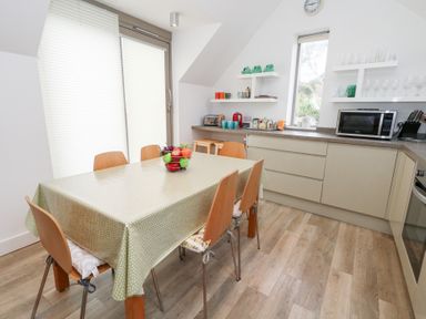 A kitchen with a dining table and chairs at Coastguard Lookout in Wyke Regis