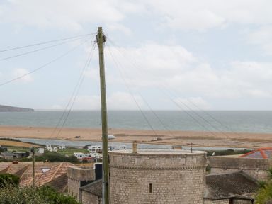 A view of the beach and sea with power lines at Coastguard Lookout in Wyke Regis