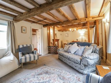A living room with a sofa and armchair at White Gates in Banham