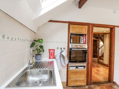 A kitchen with a sink, plant, and oven at White Gates in Banham