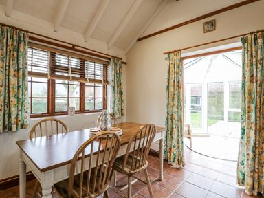 A dining room with a table and chairs at White Gates in Banham