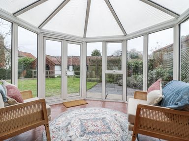 A conservatory with seating and a view of the garden at White Gates in Banham