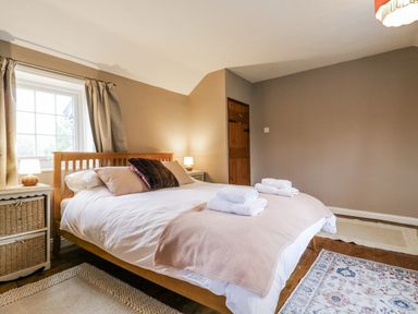 A bedroom with a bed and nightstand at White Gates in Banham
