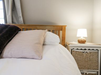 A bedroom with a bed and lamp at White Gates in Banham
