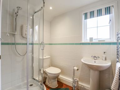 A bathroom featuring a shower, toilet, and sink at White Gates in Banham